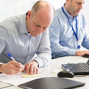 Male office worker writing down notes
